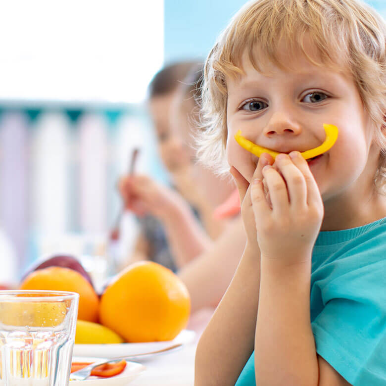 Lebensmittel-Großhandel WEIGAND Ihr Frischelogisitiker in Rosenheim Kind lächelt mit Paprika